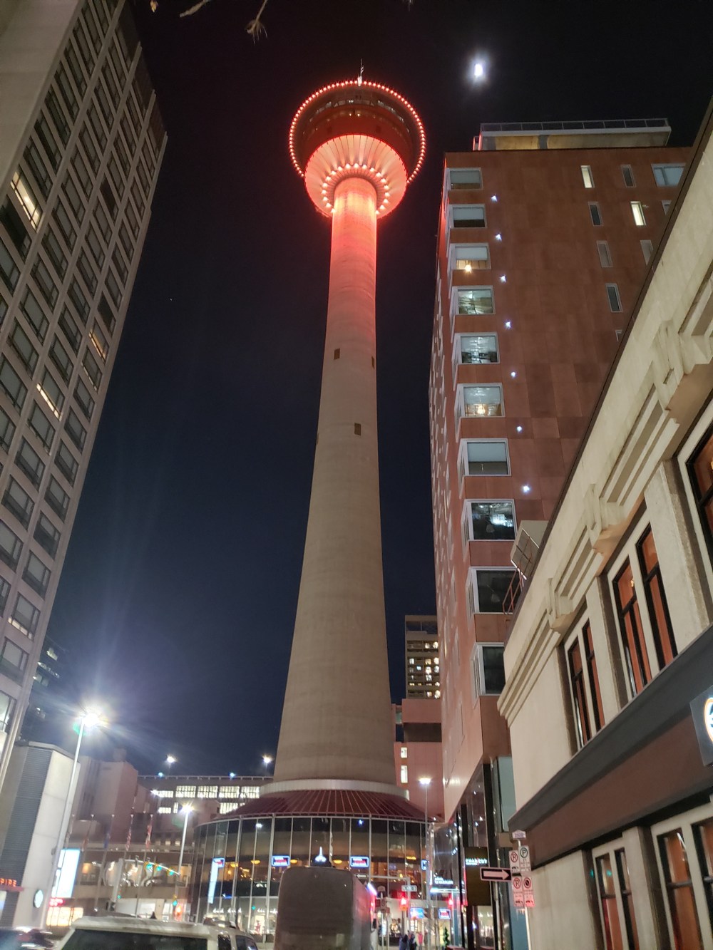 The photo showing the Calgary Tower in the evening with the exterior lights on.